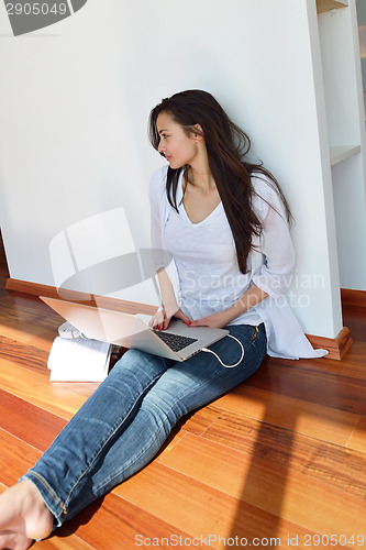 Image of relaxed young woman at home working on laptop computer