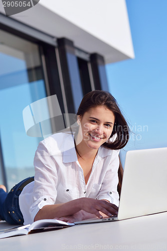 Image of relaxed young woman at home working on laptop computer