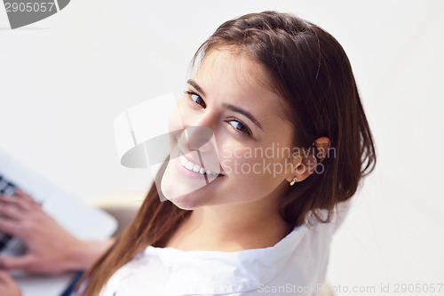 Image of relaxed young woman at home working on laptop computer