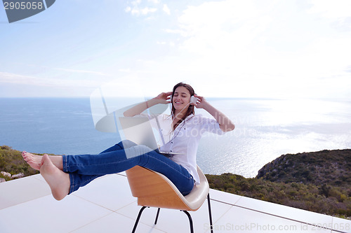 Image of relaxed young woman at home working on laptop