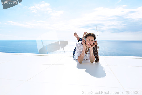 Image of girl listening to the music on white headphones