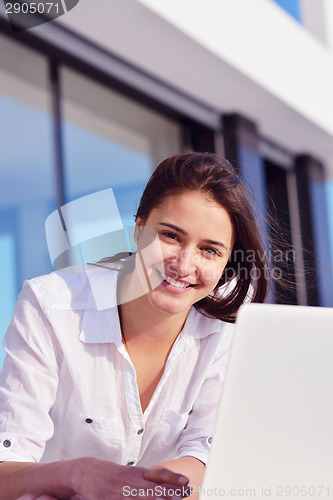 Image of relaxed young woman at home working on laptop computer