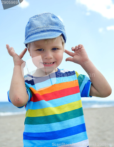 Image of Small boy holds his hands over ears not to hear