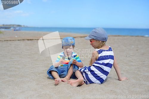 Image of Two kids sitting on the beach