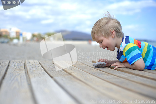 Image of Boy playing on a wooden walkway on the beach