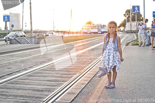 Image of Lonely girl waiting on a city tram station