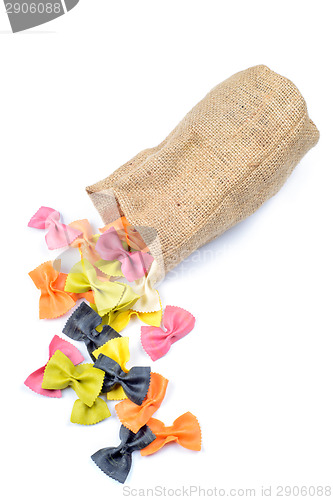 Image of Multicolored farfalle falling from canvas bag