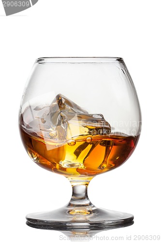 Image of Splash of whiskey with ice in glass isolated