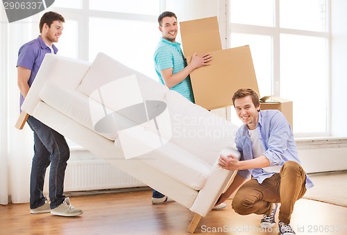 Image of smiling friends with sofa and cardboard boxes