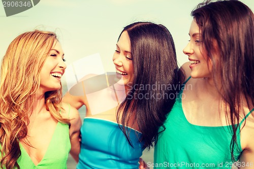 Image of smiling girls walking on the beach