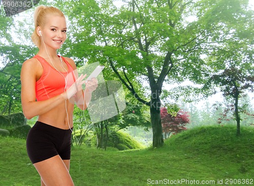 Image of smiling sporty woman with smartphone and earphones