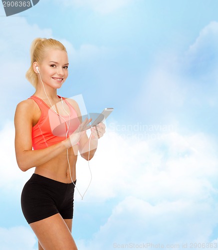 Image of smiling sporty woman with smartphone and earphones