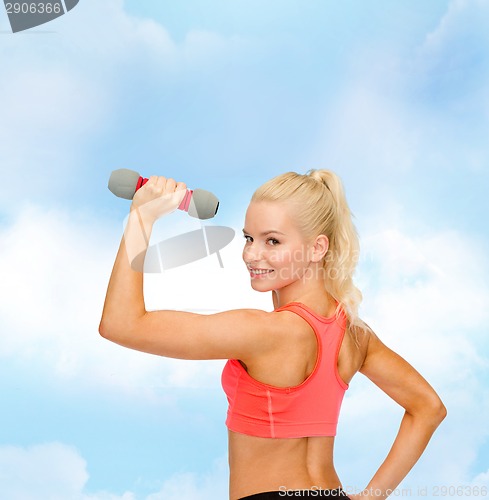 Image of young sporty woman with light dumbbell