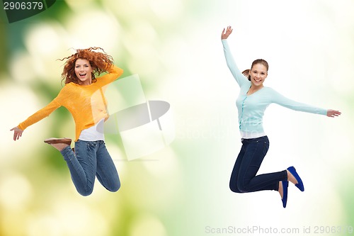 Image of smiling young women jumping in air