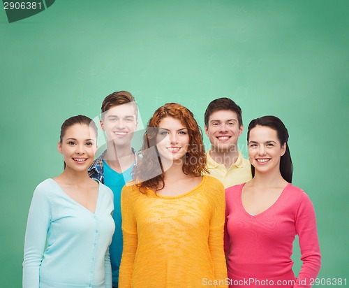 Image of group of smiling teenagers over green board