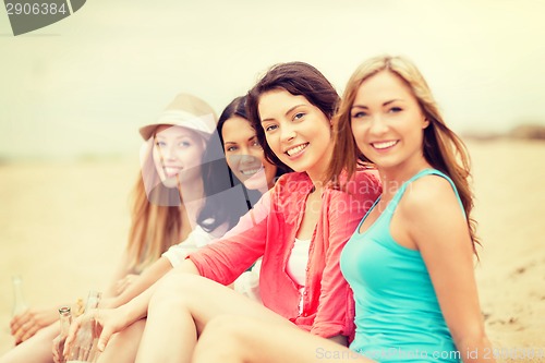 Image of smiling girls with drinks on the beach