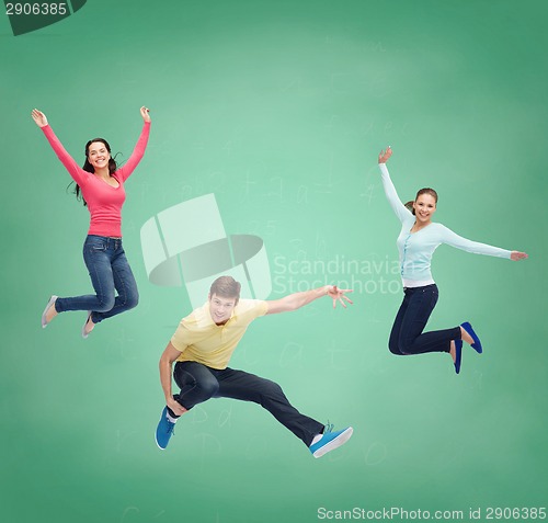 Image of group of smiling teenagers jumping in air