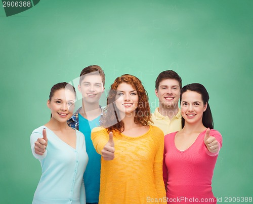 Image of group of smiling teenagers over green board