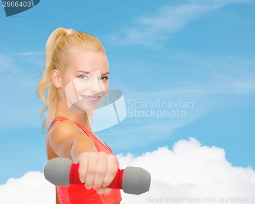 Image of smiling beautiful sporty woman with dumbbell