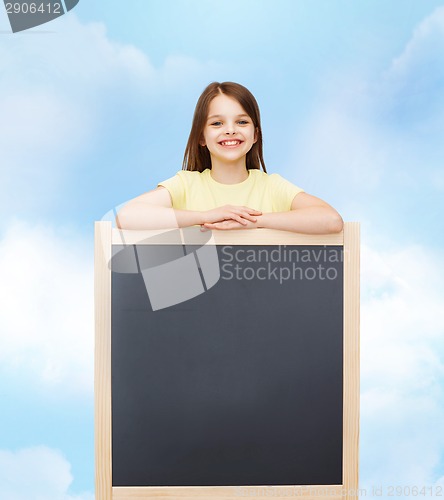 Image of happy little girl with blank blackboard