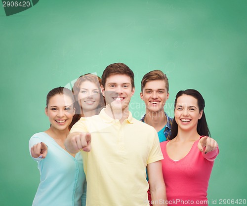 Image of group of smiling teenagers over green board