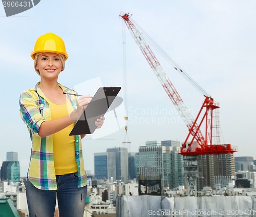 Image of smiling woman in helmet with clipboard