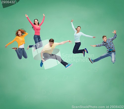 Image of group of smiling teenagers jumping in air