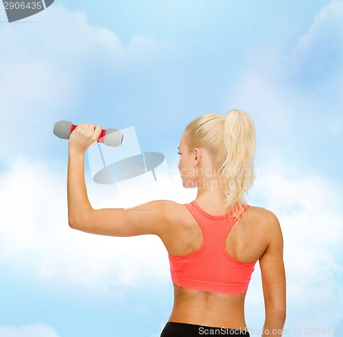 Image of young sporty woman with light dumbbell