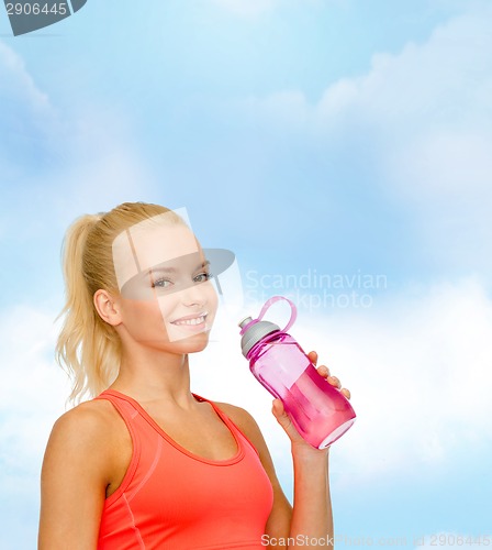 Image of smiling sporty woman with water bottle