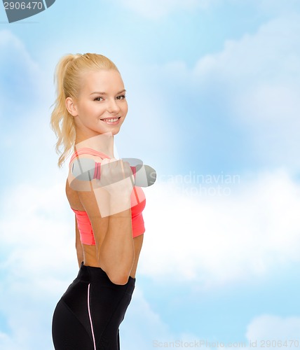 Image of smiling beautiful sporty woman with dumbbell