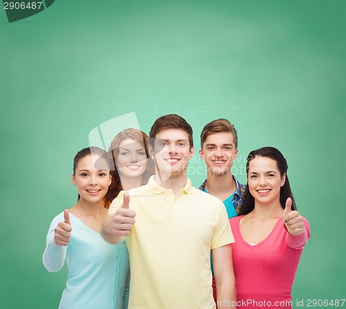 Image of group of smiling teenagers over green board