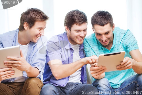 Image of smiling friends with tablet pc computers at home