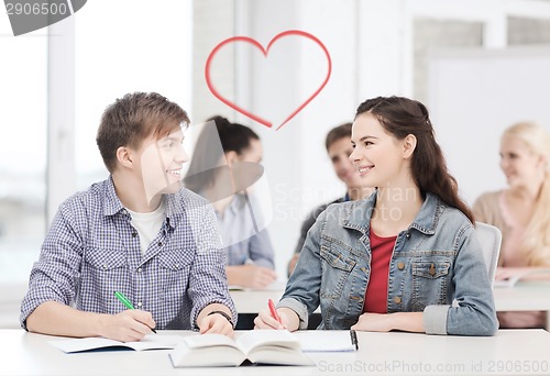 Image of two teenagers with notebooks and book at school