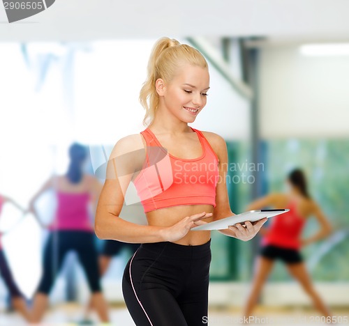 Image of smiling sporty woman with tablet pc computer