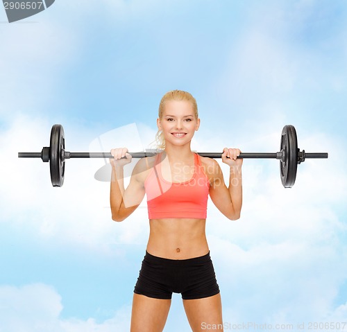 Image of smiling sporty woman exercising with barbell