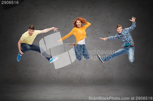 Image of group of smiling teenagers jumping in air