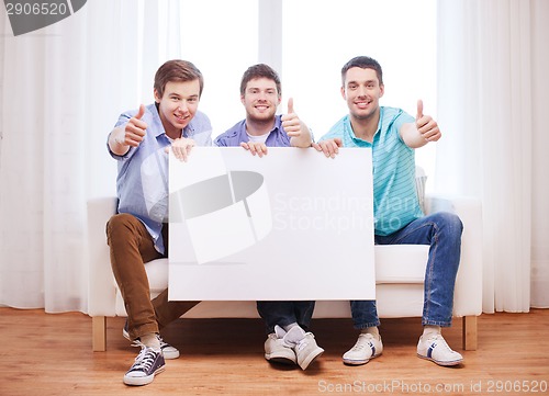 Image of happy male friends with blank white board