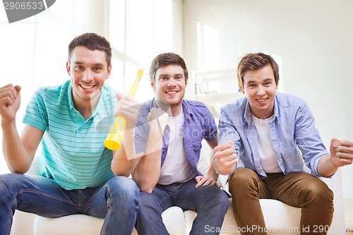 Image of happy male friends with vuvuzela