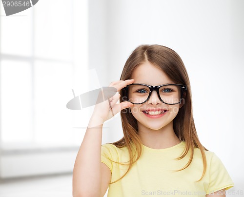 Image of smiling cute little girl in black eyeglasses