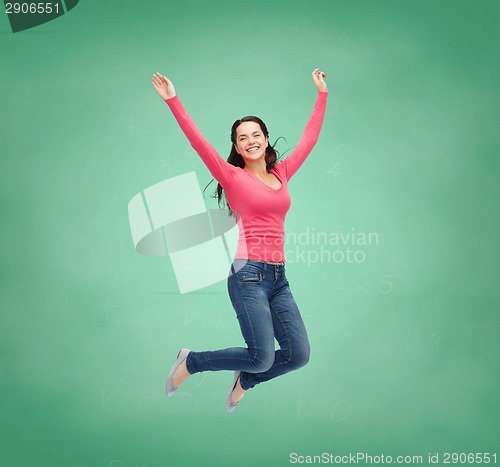 Image of smiling young woman jumping in air