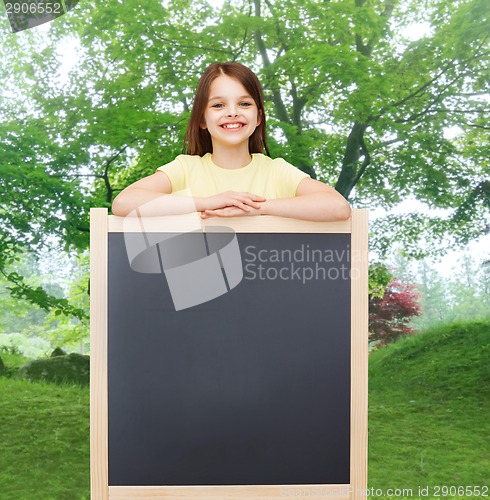 Image of happy little girl with blank blackboard