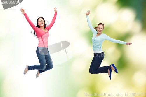 Image of smiling young women jumping in air