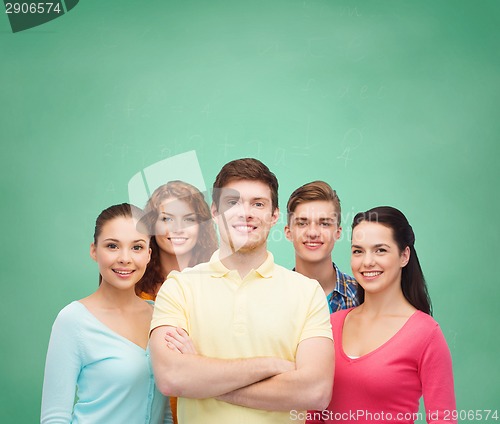 Image of group of smiling teenagers over green board