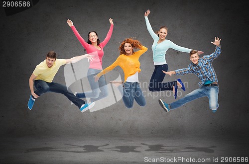 Image of group of smiling teenagers jumping in air