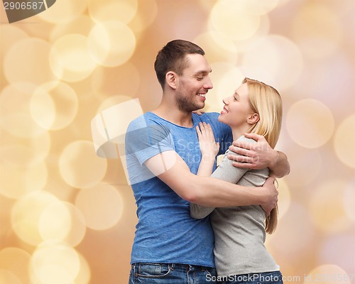 Image of smiling couple hugging and looking at each other