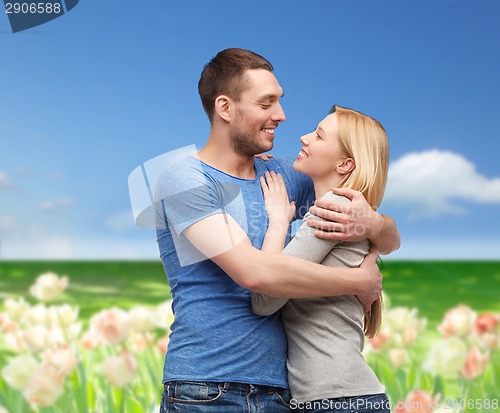 Image of smiling couple hugging and looking at each other