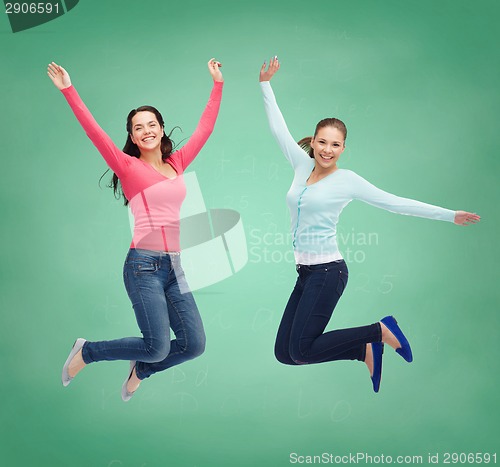 Image of smiling young women jumping in air