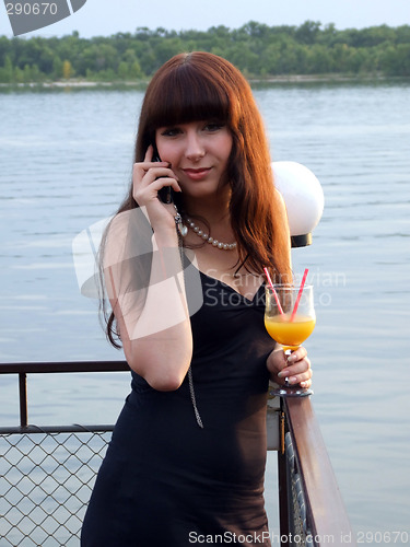 Image of The girl with a cocktail speaks to mobile phone2