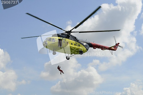 Image of The yellow MI-8 helicopter hanged with an open door. Landing of 