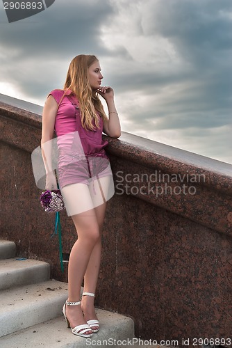 Image of Pretty girl with bouquet over city background